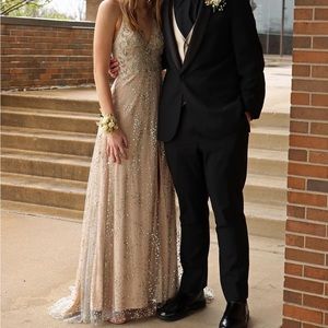 Tan prom dress with a slit and gold accents